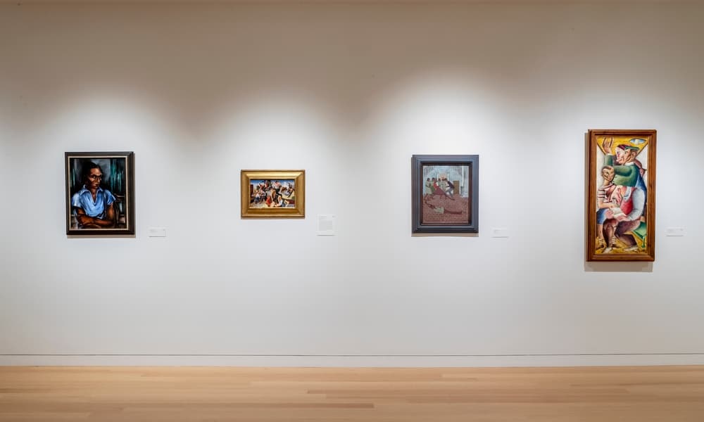 Four framed works of art with figures installed on a white wall