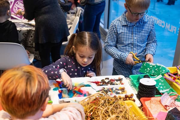 A child surveys a table of art supplies.