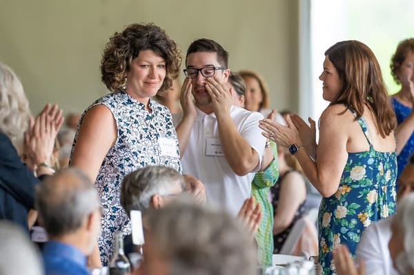 Shannon Haines, president and CEO of Waterville Creates, receives applause as she walks toward the podium to receive the 2023 Jetté Award for Leadership in the Arts.