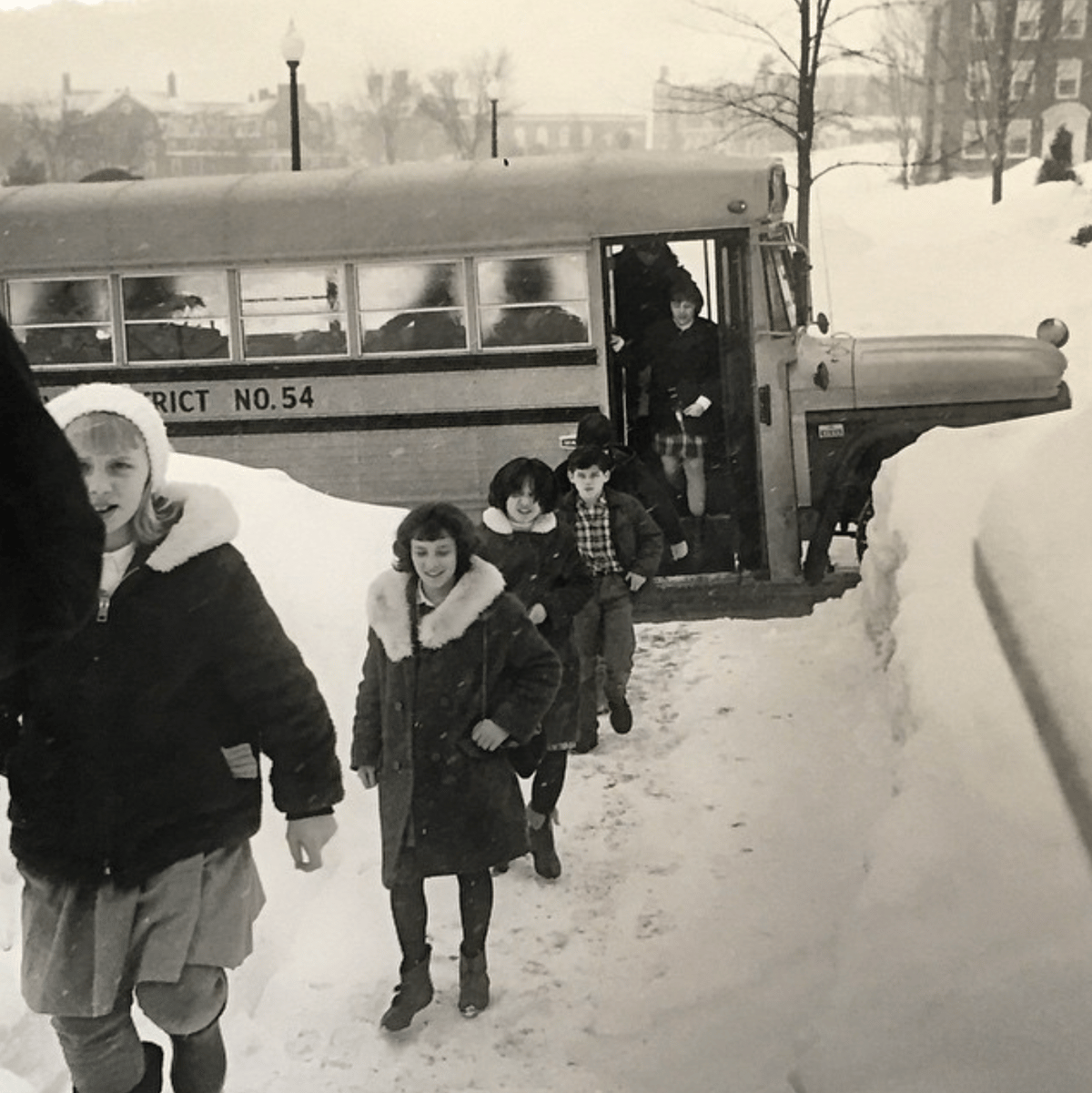 Archival image of students existing bus for class visit to museum
