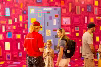 Colby Museum staff member speaks to an adult and a child