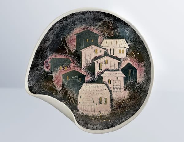 A ceramic object that depicts a folded plate with a cityscape adorned nine houses.