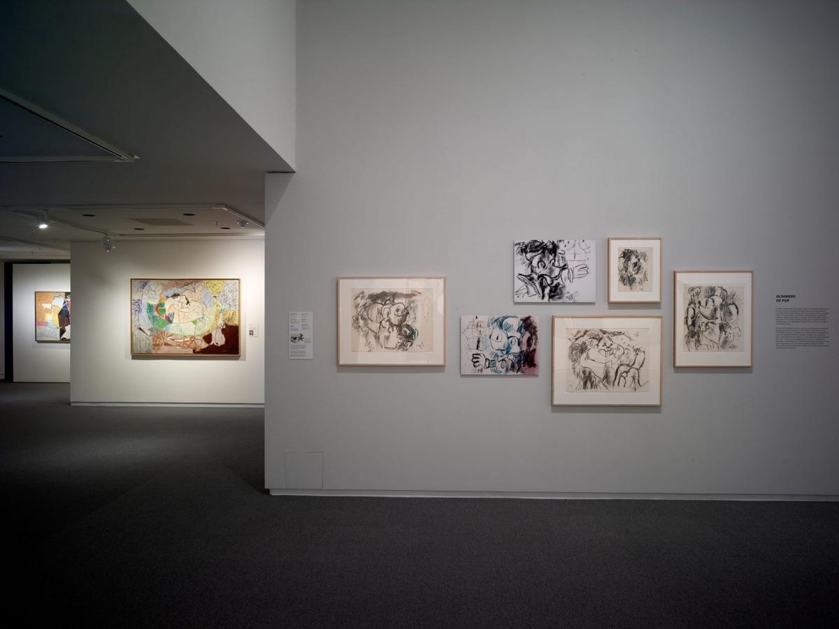 Art gallery interior with abstract and contemporary paintings on white walls.