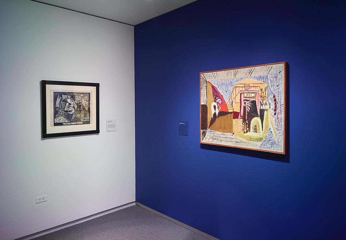 One white wall and one blue wall with a painting resting on each.