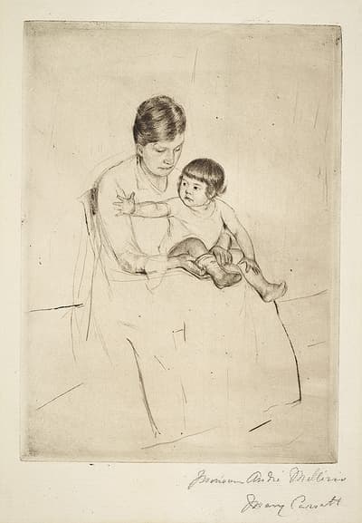A young woman sitting with a child in her lap as she places a sock on the child's foot.