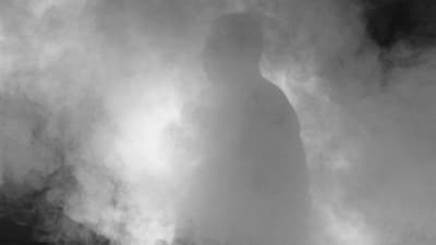 Image of a man surrounded by smoke and clouds.