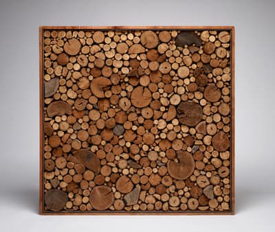 A square sculpture made up of dozens of wooden circles.