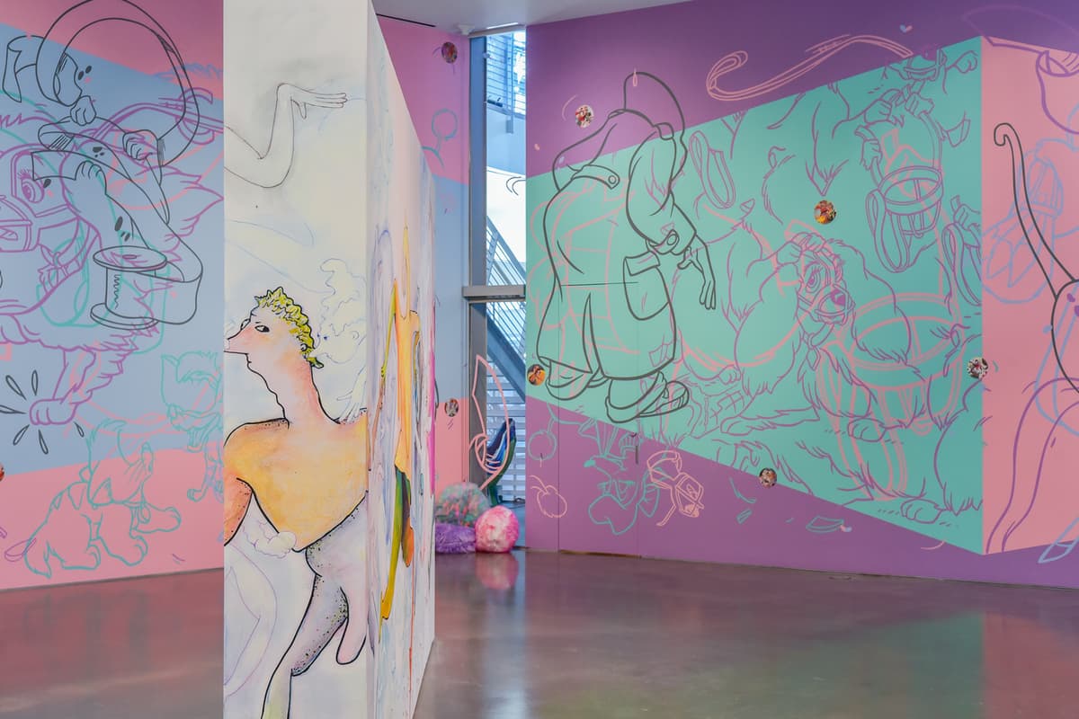 Art gallery with colorful abstract murals on walls and a polished concrete floor.