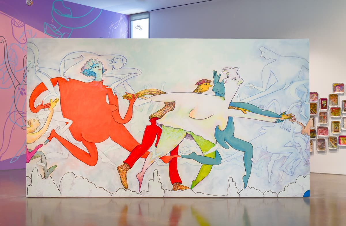 A colorful abstract painting with dynamic figures in orange, red, blue, and green hues, displayed in an art gallery.
