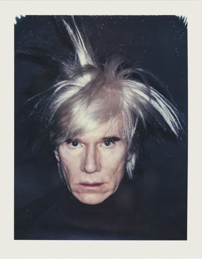 Close-up portrait of a person with light spiky hair and an intense expression.