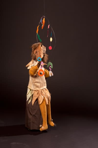 An assemblage of a central figure juggling.