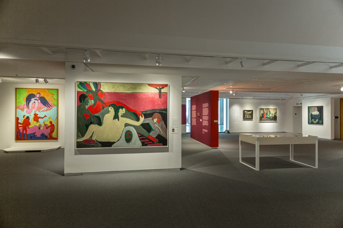 Instillation view of Bob Thompson: This House is Mine including two larger paintings, a plexiglass table, and a large red wall.
