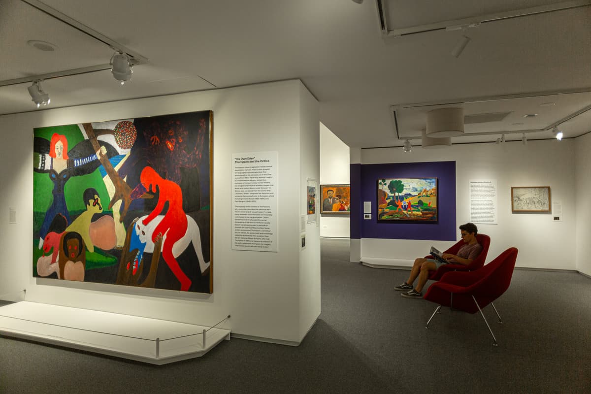 A man sitting in a chair reading surrounded by painting included in Bob Thompson: This House is Mine.
