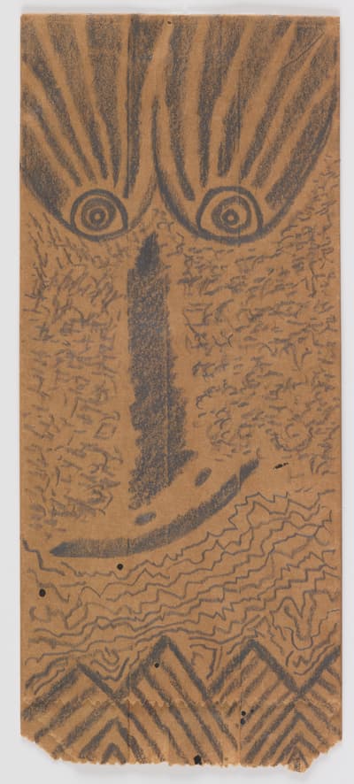 Graphite on paper bag of an elongated crooked face by Rafael Ferrer, 1980.