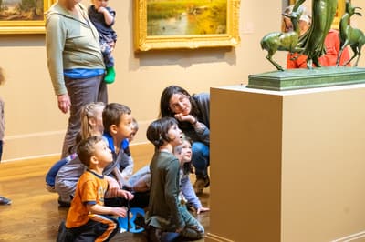 Group of seated children admiring a statue
