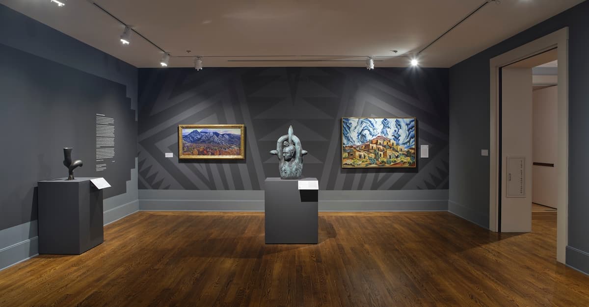 Art gallery with two paintings, a central sculpture, and geometric wall patterns.