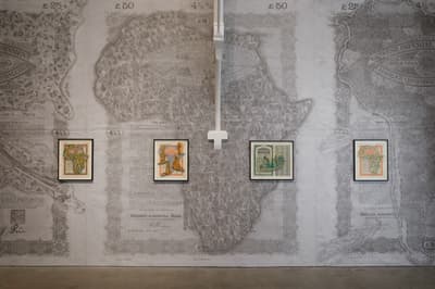Installation view of Here's the Thing, four artworks hung side by side in front of a gray background depicting Africa.