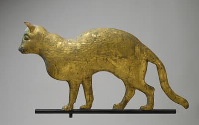 A copper weathervane ornament in the shape of a cat.