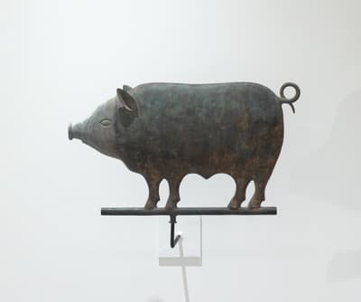 A weathervane in the shape of a pig made of copper and zinc.