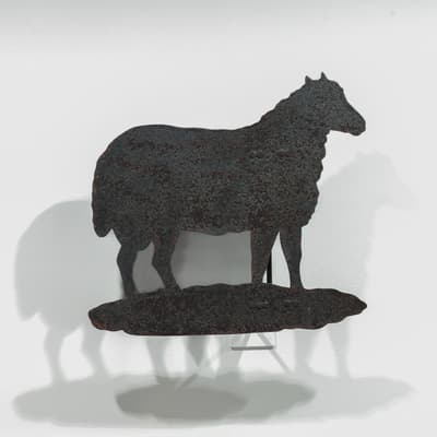 An iron weathervane weathervane in the shape of a sheep.