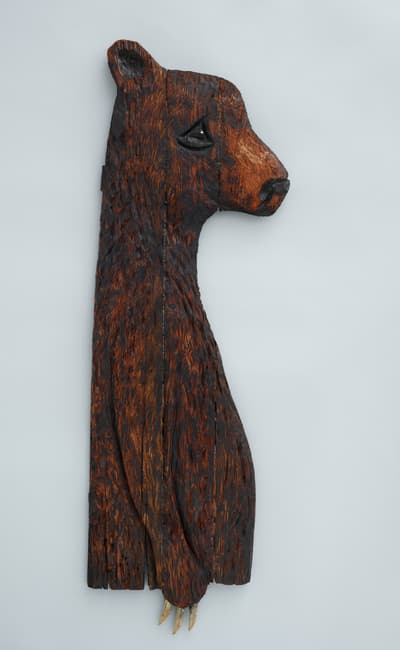 A carved wooden bear on his hind legs with claw.