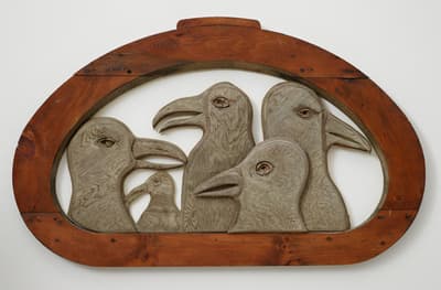 A carved wood sculpture of five seagulls in various sizes which are surrounded by a wooden circular shape.