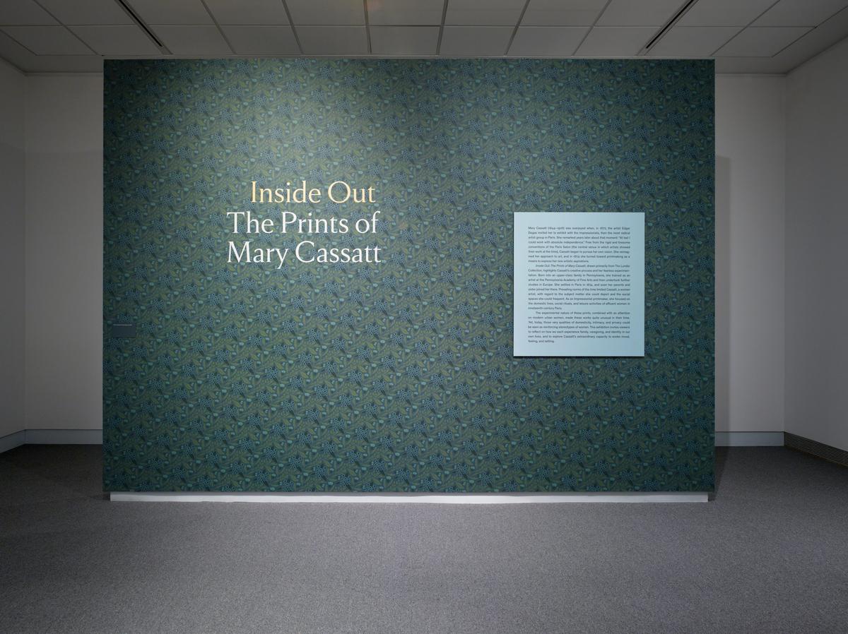 A green pattered wall that reads "Inside Out The Prints of Mary Cassat" next to smaller wall text.