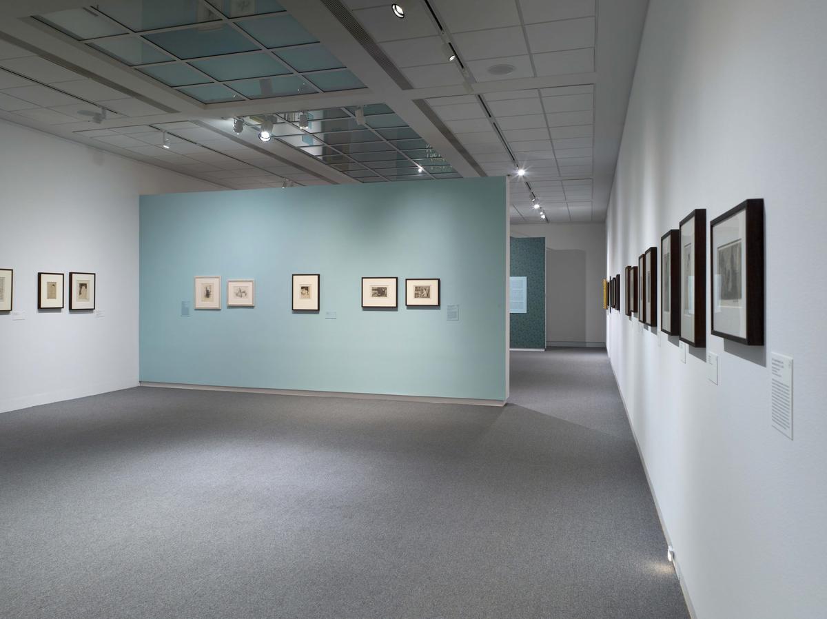 A modern art gallery with framed artworks on blue and white walls.
