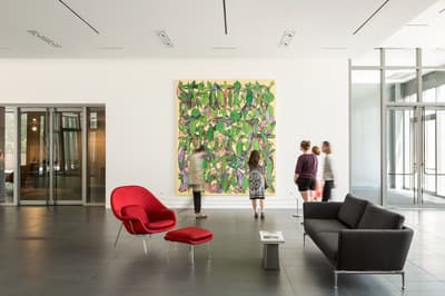 five people in Colby Museum lobby looking at painting by artist Philip Taaffe.