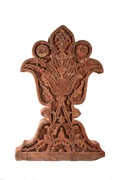 An intricately carved red sandstone sculpture.