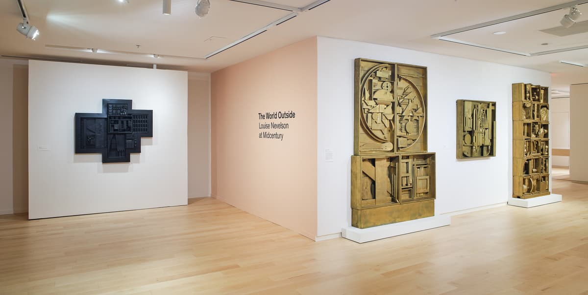 Museum gallery with mixed media hanging works of art.