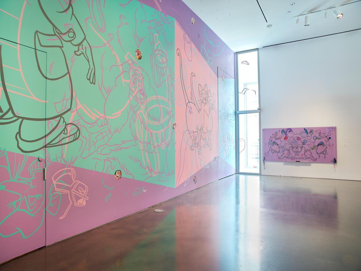 Art gallery with colorful abstract murals on walls and a polished concrete floor.