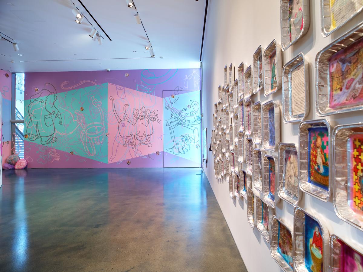 Art gallery with colorful abstract murals on walls and a polished concrete floor.
