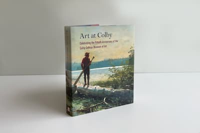 Cover of the book "Art at Colby" featuring a painting of an outdoor scene in which a man stands atop a canoe holding an oar and gazing into the landscape beyond.