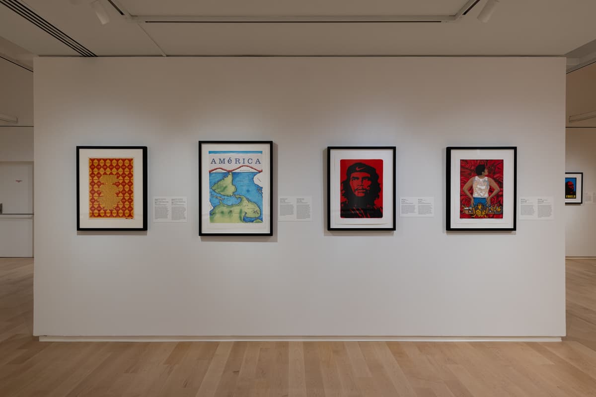 Gallery wall with four framed prints featuring bold imagery, including a map, a stylized portrait, and graphic protest art