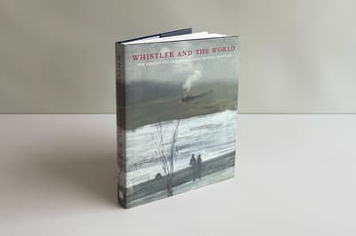 Front cover of a book propped up in front of a gray and white background. The book has a gray painting with red text, Whistler and the World