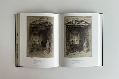 Open book displaying two pages, both with an etchings of a street scene
