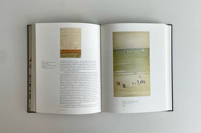 Open book displaying two pages, both with text and an art image