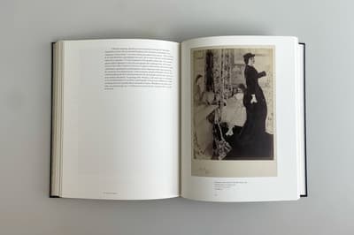 Open book displaying two pages, one with a etching of a women standing wearing a black dress and the other containing text
