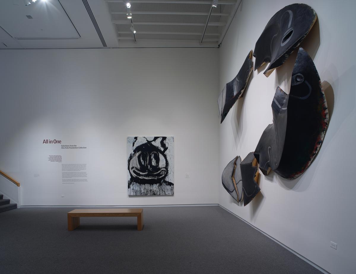 Wall-mounted black ceramic sculpture next to a black-and-white painted canvas.