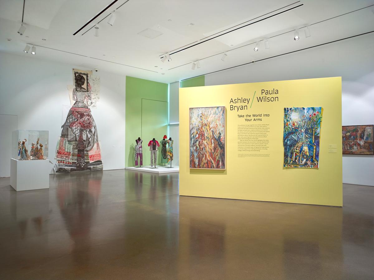 Introductory wall with text and vibrant paintings for the exhibition.