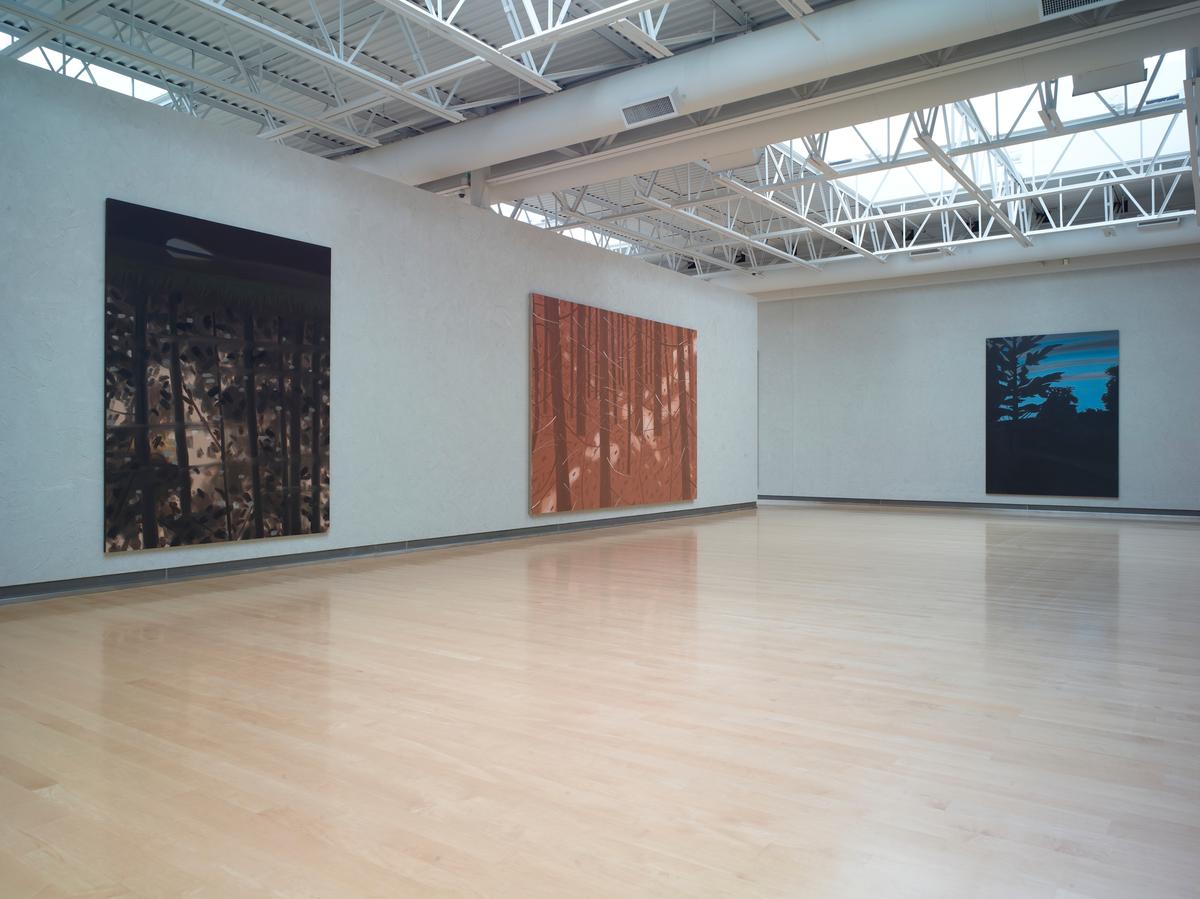 Spacious gallery with three large landscape paintings in dark, rust, and teal tones respectively.
