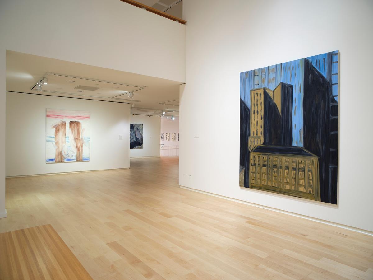 Gallery view with a large cityscape painting on the right wall and additional abstract works visible in the background through a hallway.