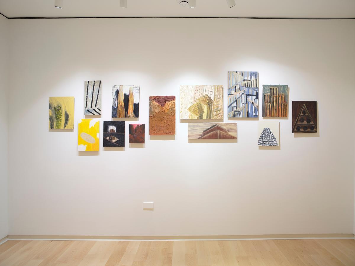 Grid of thirteen abstract architectural paintings and drawings installed on a white wall.