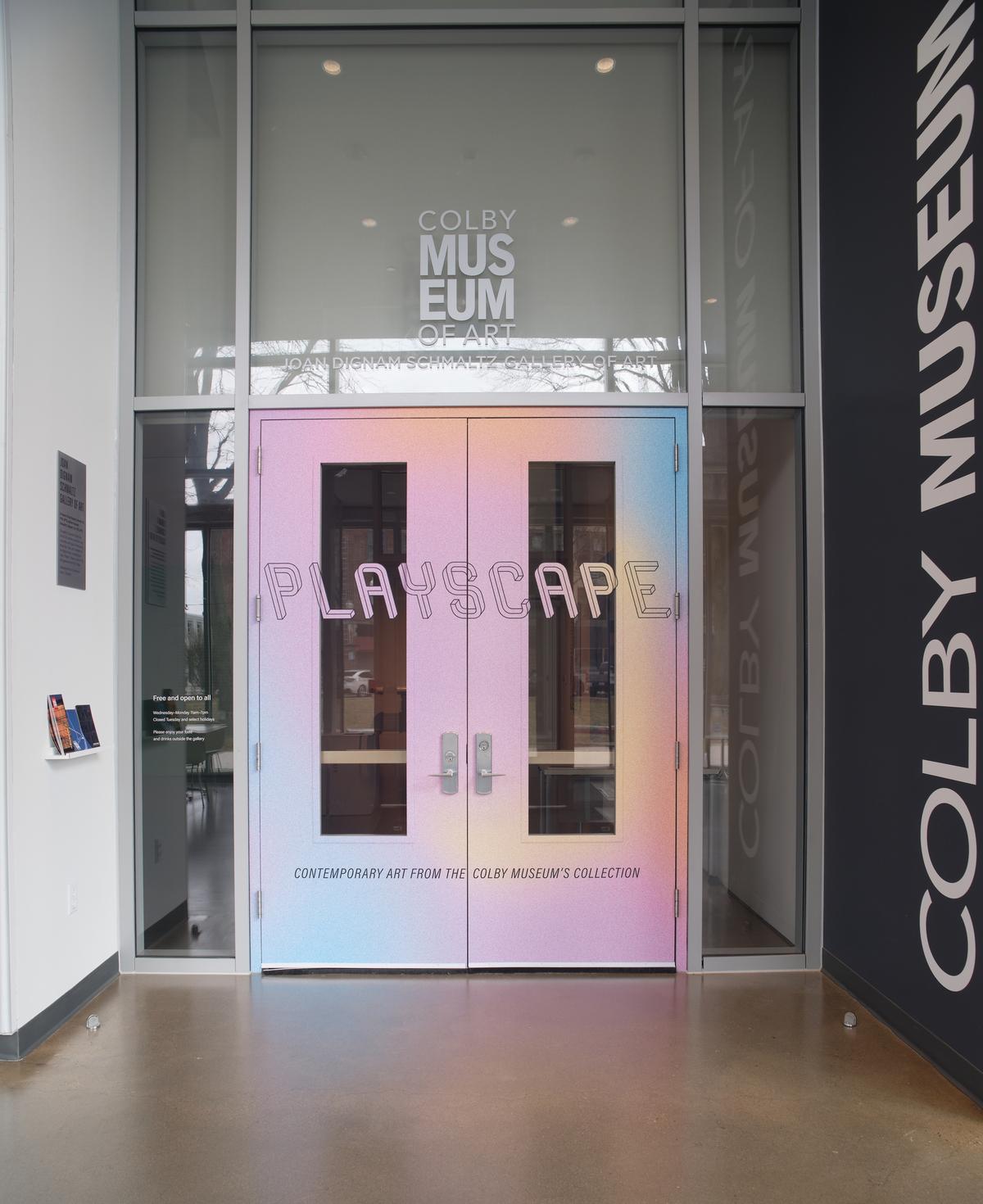 Glass entrance doors with colorful gradient film and the word “PLAYSCAPE” in playful block lettering.