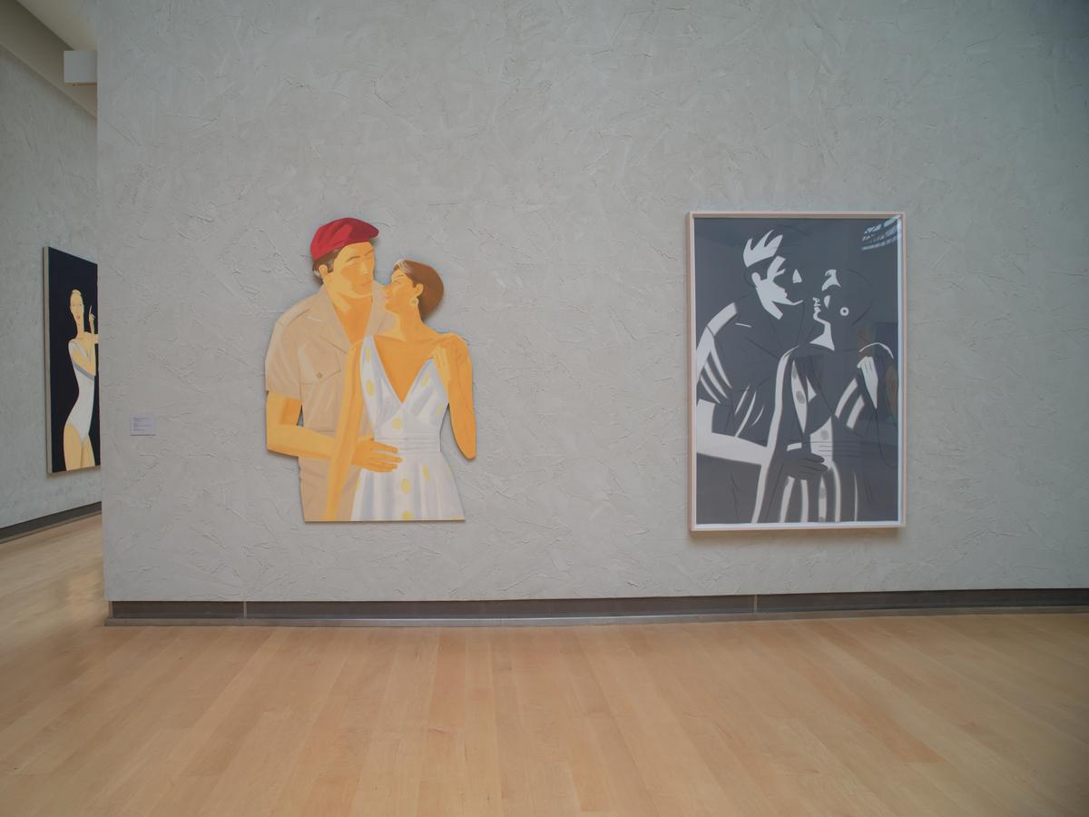 Two artworks hung side by side on a textured wall: one, a silhouette of an embracing couple in color; the other, a framed grayscale depiction of the same pair.