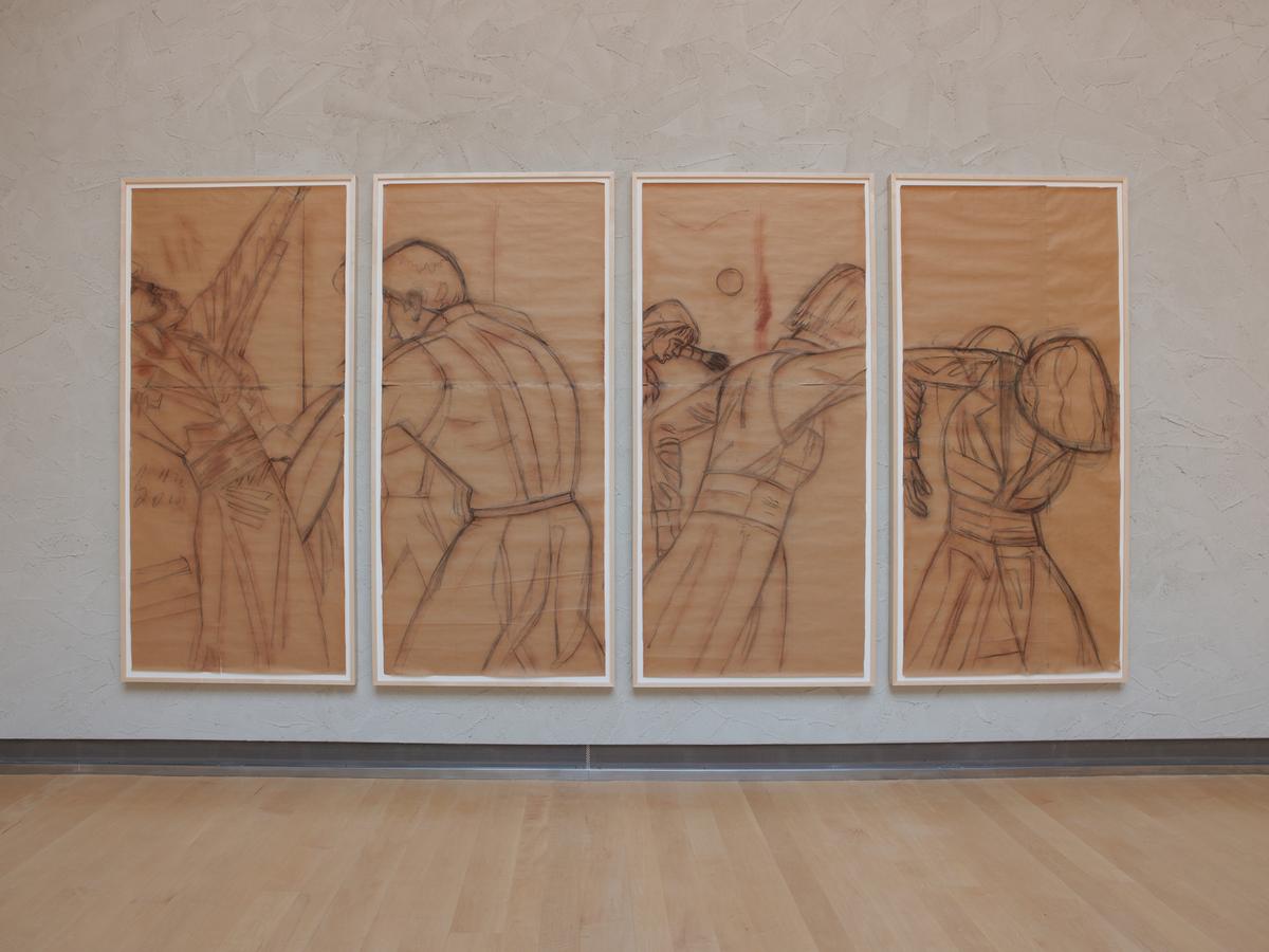 Four large preparatory figure drawings mounted side-by-side on a pale gallery wall.