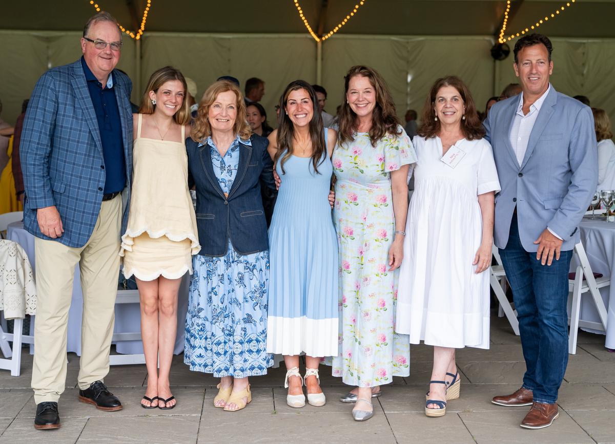 Seven individuals posed side by side for a group picture.