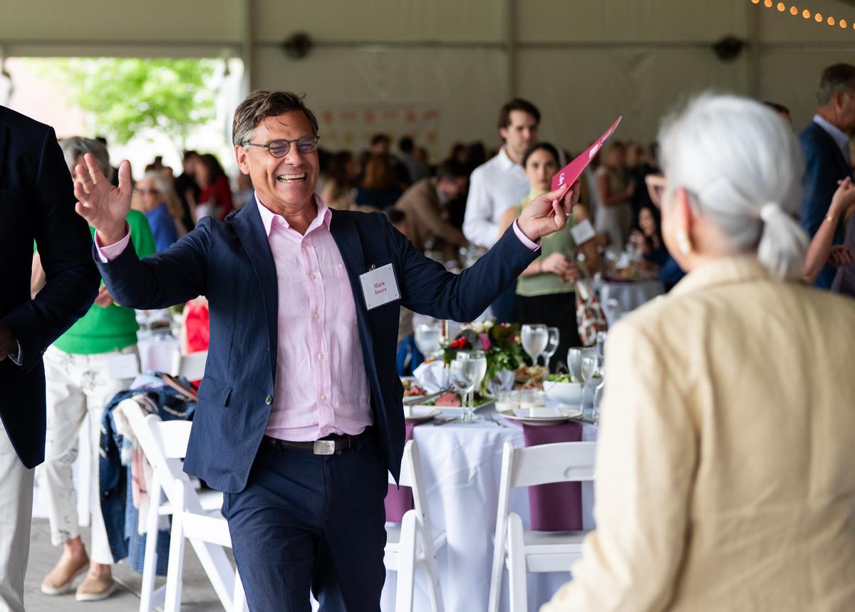 Mark Bessire smiling with arms open to embrace Theresa Secord