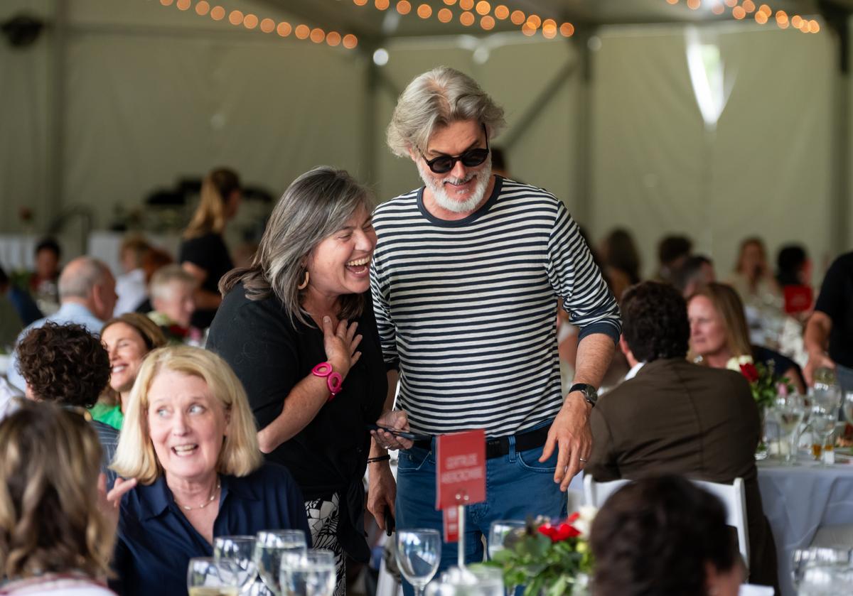 Guests including artist Mo Willems taking their seats under an event tent.
